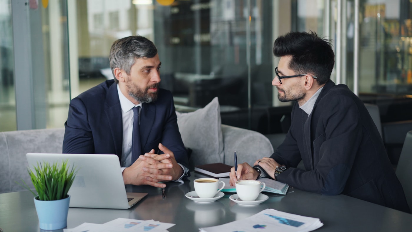 Two negotiators discussing a deal across a desk