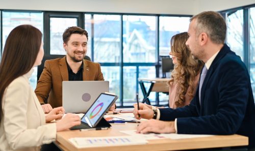 Business meeting in an office, workers discussing business affairs. Gadgets and papers with charts on the table