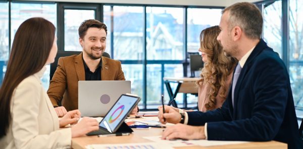 Business meeting in an office, workers discussing business affairs. Gadgets and papers with charts on the table